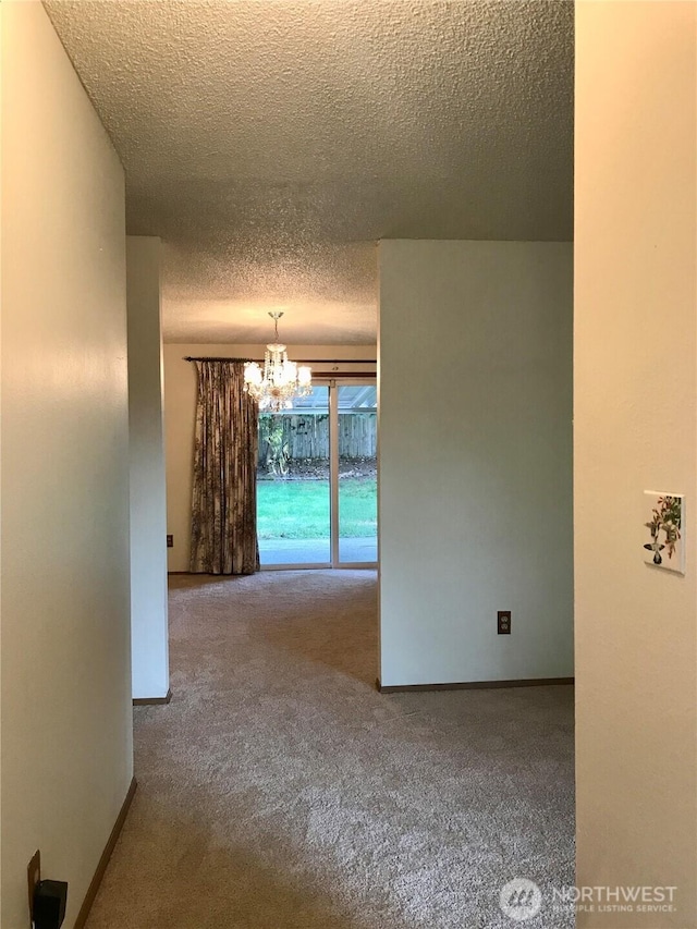 7613 12th Way, Olympia, WA 98516 - hallway featuring a chandelier, a textured ceiling, carpet, and baseboards