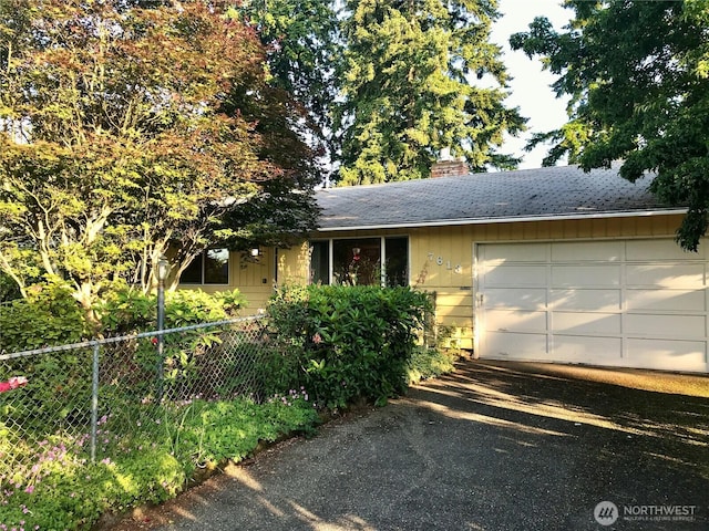 7613 12th Way, Olympia, WA 98516 - view of front of home featuring asphalt driveway, a chimney, an attached garage, and roof with shingles