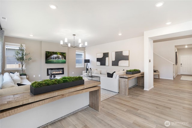 3266 SW Pier Ln, Port Orchard, WA 98367 - living room featuring light wood-type flooring, a chandelier, recessed lighting, a glass covered fireplace, and plenty of natural light