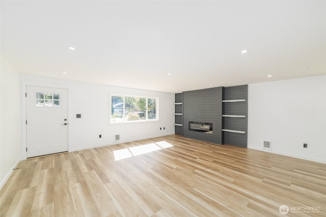 15310 25th St E, Tacoma, WA 98445 - unfurnished living room with healthy amount of natural light, light wood finished floors, recessed lighting, baseboards, and a large fireplace