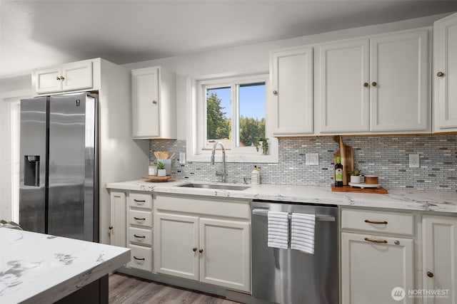 8517 188th Ct E, Puyallup, WA 98375 - kitchen featuring appliances with stainless steel finishes, a sink, white cabinetry, decorative backsplash, and light stone counters