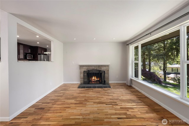 4006 147th Pl SE, Bellevue, WA 98006 - unfurnished living room featuring healthy amount of natural light, light wood-type flooring, recessed lighting, baseboards, and a stone fireplace