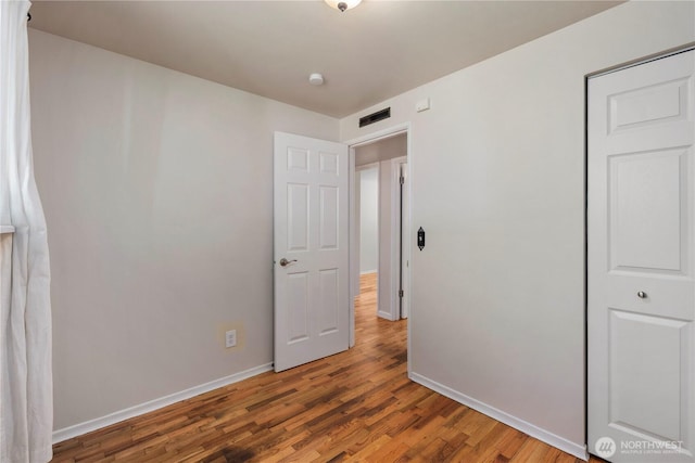 4006 147th Pl SE, Bellevue, WA 98006 - unfurnished bedroom featuring baseboards and wood finished floors