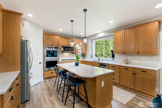 3623 148th St SE, Mill Creek, WA 98012 - kitchen featuring appliances with stainless steel finishes, a sink, a breakfast bar area, a center island, and light wood-type flooring