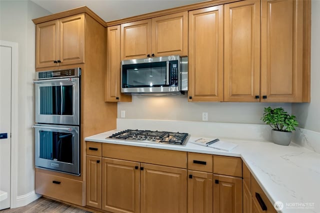 3623 148th St SE, Mill Creek, WA 98012 - kitchen featuring appliances with stainless steel finishes, light stone countertops, and light wood finished floors