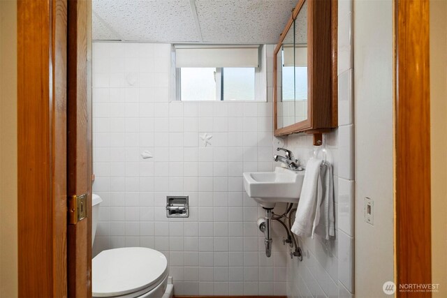 2921 Ellis St, Bellingham, WA 98225 - bathroom with a drop ceiling, toilet, tile walls, and a sink