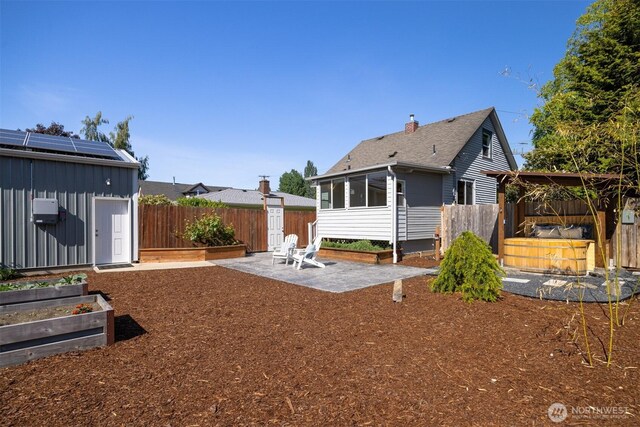 2921 Ellis St, Bellingham, WA 98225 - rear view of house with a garden, a patio, a fenced backyard, and a sunroom