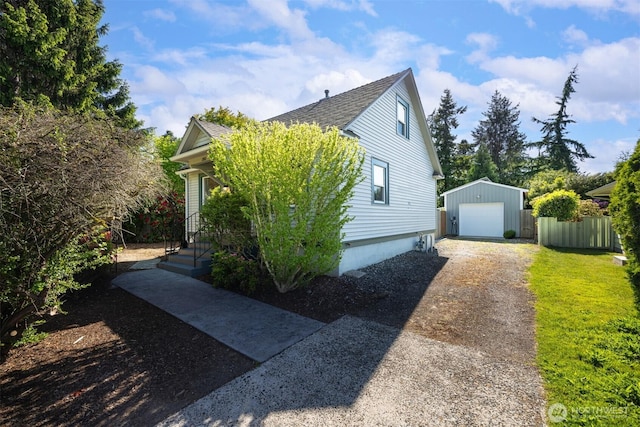 2921 Ellis St, Bellingham, WA 98225 - view of home's exterior featuring an outdoor structure, dirt driveway, a detached garage, and roof with shingles