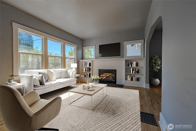 914 N Cedar St, Tacoma, WA 98406 - living area featuring a glass covered fireplace, wood finished floors, and baseboards