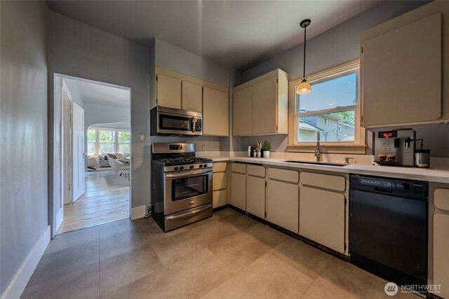 914 N Cedar St, Tacoma, WA 98406 - kitchen featuring stainless steel appliances, a sink, light countertops, decorative light fixtures, and baseboards