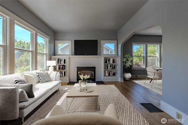 914 N Cedar St, Tacoma, WA 98406 - living area featuring plenty of natural light, arched walkways, a fireplace with flush hearth, and wood finished floors