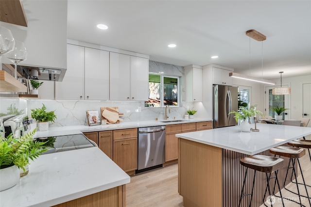 30156 2nd Pl SW, Federal Way, WA 98023 - kitchen featuring stainless steel appliances, a sink, a kitchen breakfast bar, light wood-style flooring, and tasteful backsplash