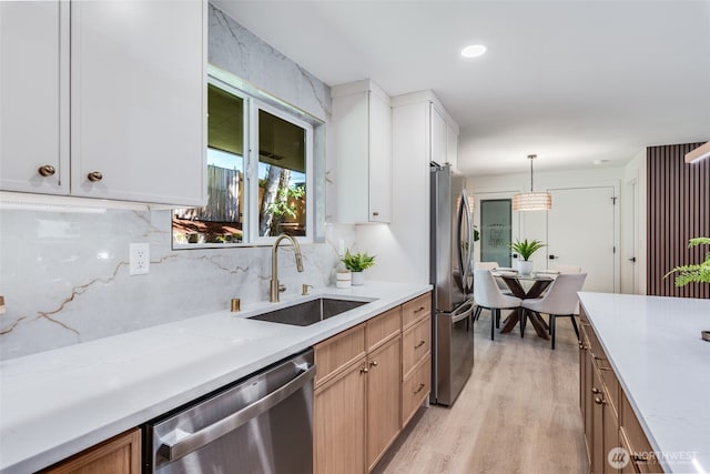 30156 2nd Pl SW, Federal Way, WA 98023 - kitchen featuring appliances with stainless steel finishes, a sink, light wood-style flooring, backsplash, and decorative light fixtures