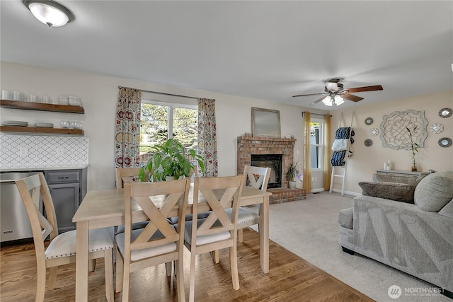 404 Jewell St, Enumclaw, WA 98022 - dining space featuring ceiling fan, a fireplace, light wood-style floors, and baseboards
