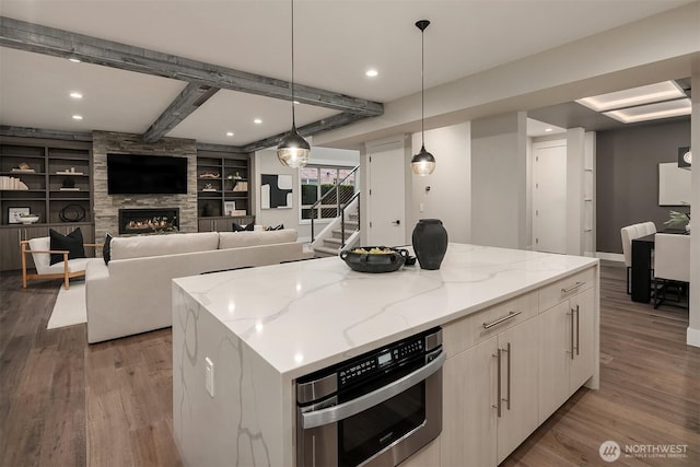 326 7th Ave S, Kirkland, WA 98033 - kitchen featuring wood finished floors, oven, a kitchen island, light stone countertops, and pendant lighting