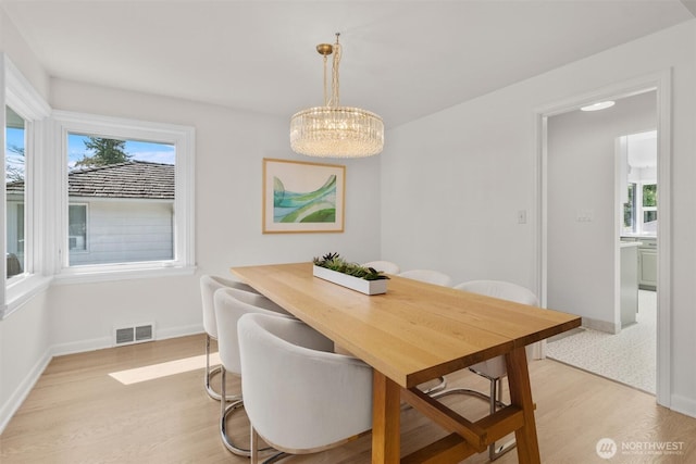 1536 NW 100th St, Seattle, WA 98177 - dining space with light wood-style floors, a chandelier, and baseboards