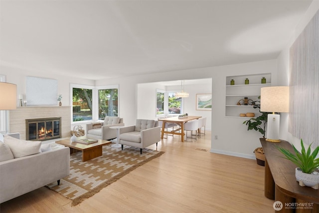 1536 NW 100th St, Seattle, WA 98177 - living area featuring light wood finished floors, a glass covered fireplace, and built in shelves