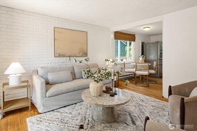 9010 13th Ave SW, Seattle, WA 98106 - living room featuring wood finished floors, a baseboard heating unit, and brick wall