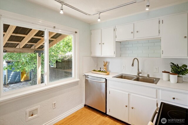 9010 13th Ave SW, Seattle, WA 98106 - kitchen featuring stainless steel dishwasher, a sink, track lighting, baseboards, and white cabinets