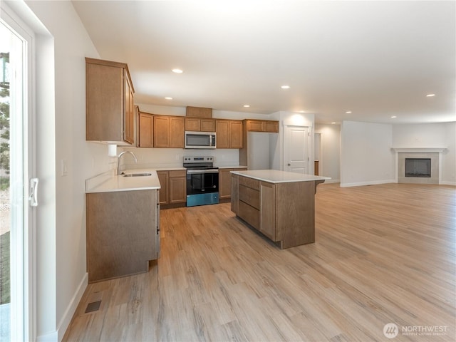 10 Salmon Dr, Wenatchee, WA 98801 - kitchen featuring appliances with stainless steel finishes, a sink, a center island, light wood finished floors, and recessed lighting