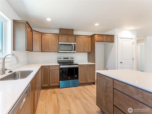 10 Salmon Dr, Wenatchee, WA 98801 - kitchen with appliances with stainless steel finishes, a sink, light wood-style flooring, brown cabinetry, and recessed lighting