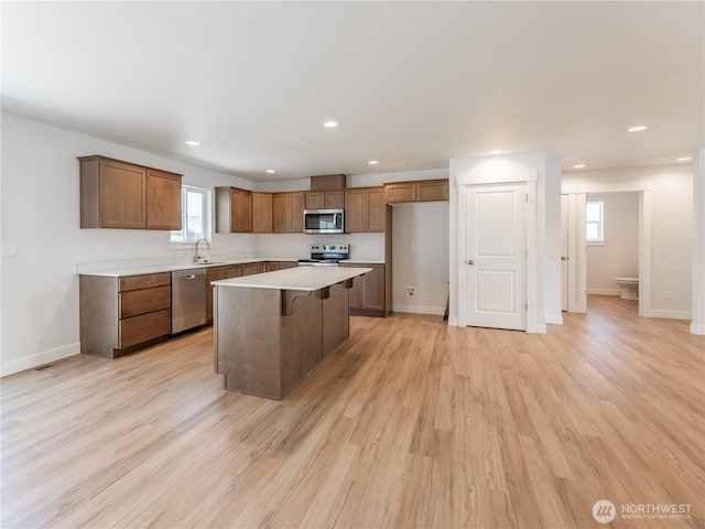 10 Salmon Dr, Wenatchee, WA 98801 - kitchen featuring appliances with stainless steel finishes, brown cabinets, a center island, a kitchen bar, and recessed lighting