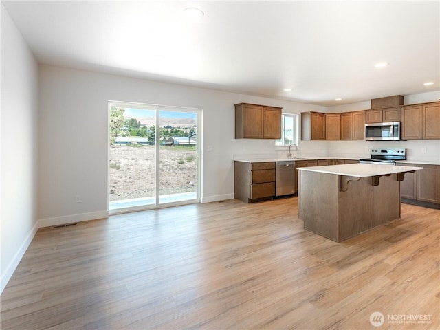 10 Salmon Dr, Wenatchee, WA 98801 - kitchen featuring stainless steel appliances, a sink, a breakfast bar, baseboards, and plenty of natural light