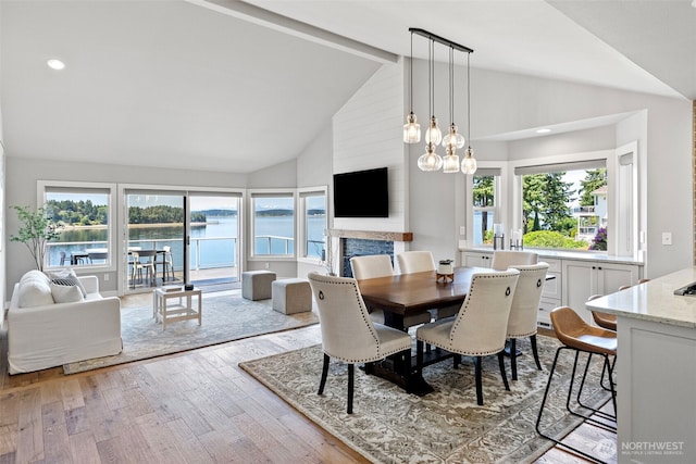 52 Chapman Loop Unit D, Steilacoom, WA 98388 - dining space with wood finished floors, beamed ceiling, high vaulted ceiling, a fireplace, and a chandelier