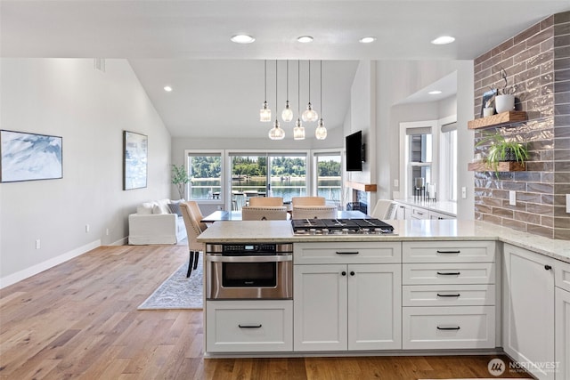 52 Chapman Loop Unit D, Steilacoom, WA 98388 - kitchen with stainless steel appliances, lofted ceiling, light stone counters, open shelves, and open floor plan
