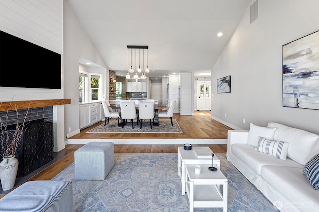 52 Chapman Loop Unit D, Steilacoom, WA 98388 - living area with wood finished floors, a fireplace with flush hearth, recessed lighting, a chandelier, and baseboards
