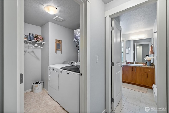 5822 N 35th St Unit C9, Tacoma, WA 98407 - laundry room with a textured ceiling, washing machine and clothes dryer, light tile patterned floors, and baseboard heating