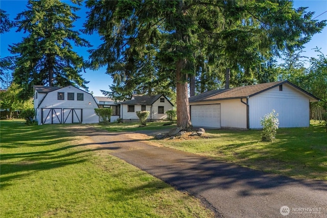 1416 S 88th St, Tacoma, WA 98444 - view of front of home with an outbuilding, a detached garage, asphalt driveway, and a front yard