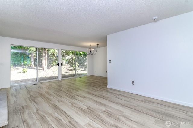 32622 39th Ave SW, Federal Way, WA 98023 - spare room featuring a chandelier, light wood-style flooring, a textured ceiling, a smoke detector, and baseboards
