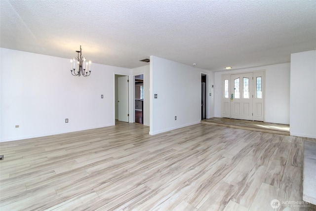 32622 39th Ave SW, Federal Way, WA 98023 - unfurnished living room with a chandelier, light wood-style flooring, and a textured ceiling