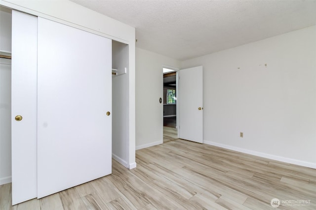32622 39th Ave SW, Federal Way, WA 98023 - unfurnished bedroom featuring a closet, light wood-style flooring, a textured ceiling, and baseboards