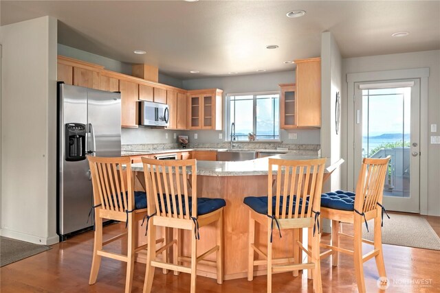 1257 Canterbury Ln, Oak Harbor, WA 98277 - kitchen featuring appliances with stainless steel finishes, light wood finished floors, light brown cabinetry, a peninsula, and recessed lighting