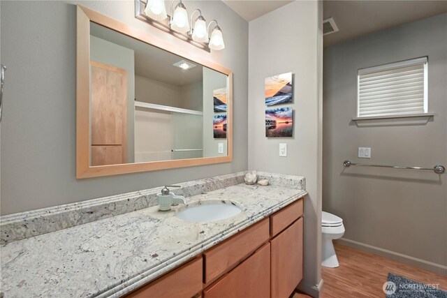 1257 Canterbury Ln, Oak Harbor, WA 98277 - bathroom with wood finished floors, vanity, toilet, baseboards, and a shower with shower door