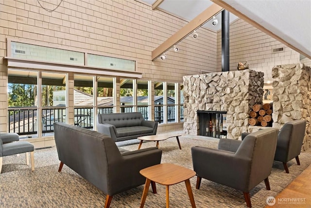 6268 137th Pl NE Unit 244, Redmond, WA 98052 - living area featuring a towering ceiling, track lighting, a stone fireplace, and wood finished floors