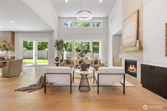 14511 SE 21st Pl, Bellevue, WA 98007 - living area featuring a towering ceiling, a tiled fireplace, light wood-type flooring, and recessed lighting