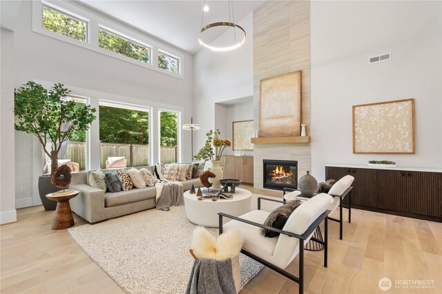 14511 SE 21st Pl, Bellevue, WA 98007 - living room with a high ceiling, light wood finished floors, a tile fireplace, and baseboards
