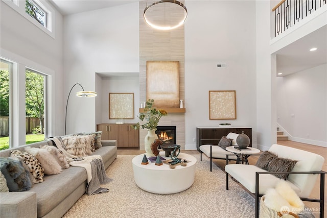 14511 SE 21st Pl, Bellevue, WA 98007 - living room featuring a towering ceiling, stairs, a fireplace, baseboards, and wood finished floors