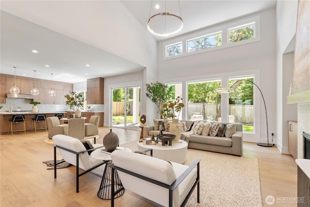 14511 SE 21st Pl, Bellevue, WA 98007 - living room with light wood finished floors, a high ceiling, a fireplace, and recessed lighting