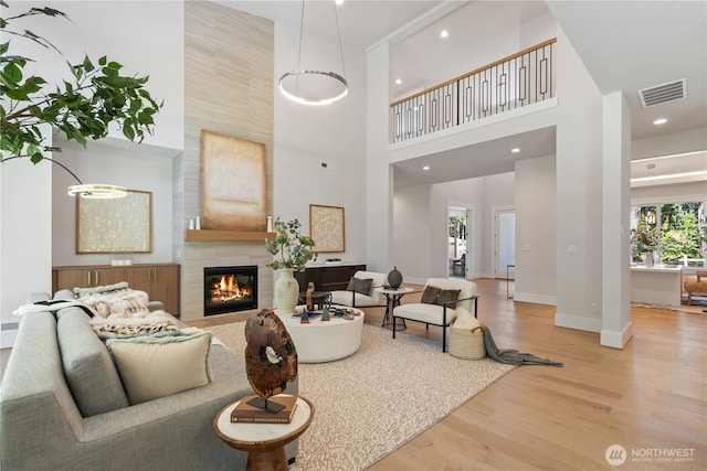 14511 SE 21st Pl, Bellevue, WA 98007 - living area featuring wood finished floors, a towering ceiling, baseboards, a tiled fireplace, and recessed lighting