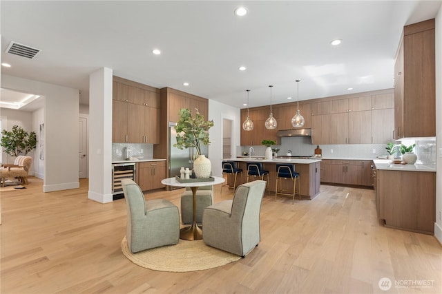 14511 SE 21st Pl, Bellevue, WA 98007 - dining room featuring beverage cooler, light wood-style floors, recessed lighting, and baseboards