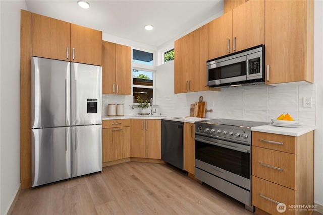 3609 Linden Ave N, Seattle, WA 98103 - kitchen featuring appliances with stainless steel finishes, a sink, light countertops, backsplash, and light wood finished floors