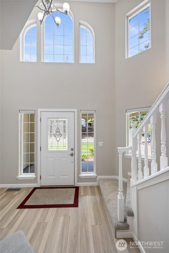 6579 Gleneagle Ave SW, Port Orchard, WA 98367 - foyer entrance with wood finished floors, a high ceiling, plenty of natural light, baseboards, and a chandelier