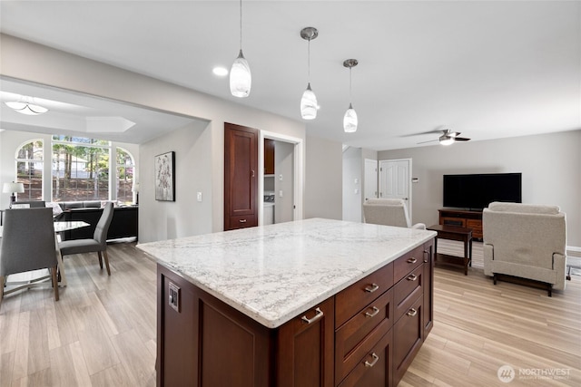 6579 Gleneagle Ave SW, Port Orchard, WA 98367 - kitchen with open floor plan, hanging light fixtures, light stone countertops, washer / dryer, and a ceiling fan