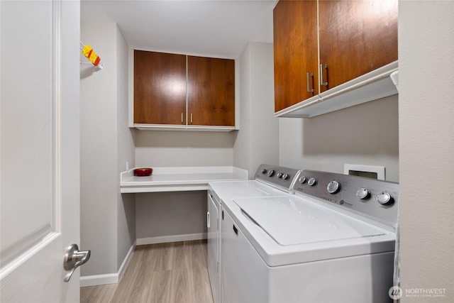 6579 Gleneagle Ave SW, Port Orchard, WA 98367 - laundry room with cabinet space, washer and dryer, light wood-type flooring, and baseboards