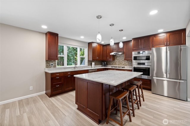 6579 Gleneagle Ave SW, Port Orchard, WA 98367 - kitchen featuring stainless steel appliances, a sink, backsplash, light wood finished floors, and a center island