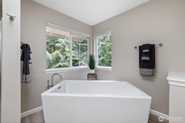 6579 Gleneagle Ave SW, Port Orchard, WA 98367 - bathroom featuring baseboards, a freestanding bath, and wood finished floors